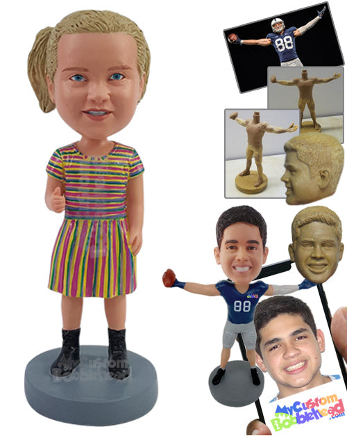 Nice young girl wearing a colorful dress and boots, giving a thumbs up Personalized Bobblehead